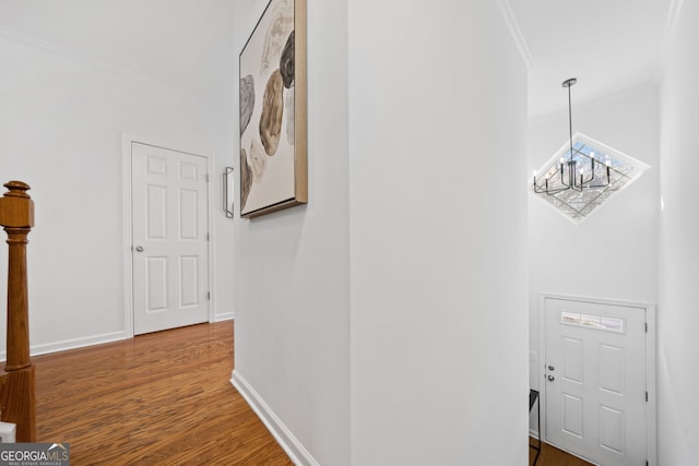hallway featuring wood finished floors, baseboards, and ornamental molding