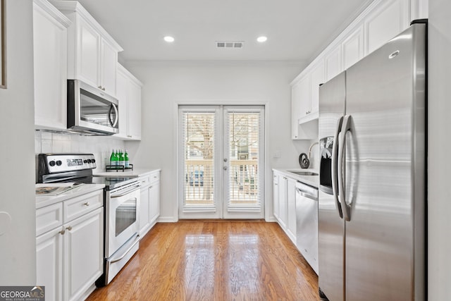 kitchen with white cabinetry, light countertops, visible vents, and appliances with stainless steel finishes