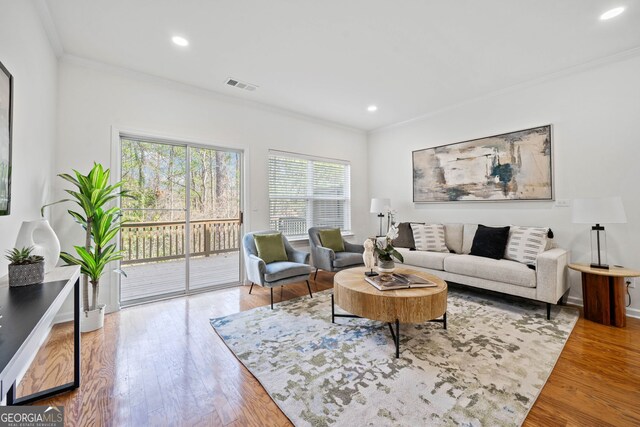 living area with visible vents, recessed lighting, crown molding, and wood finished floors