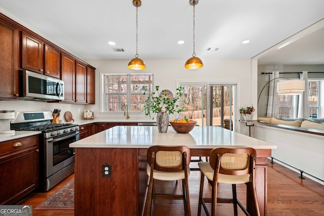 3810 Branch Bluff Ln, Cumming, GA 30040 - kitchen with visible vents, a center island, light countertops, a kitchen bar, and appliances with stainless steel finishes