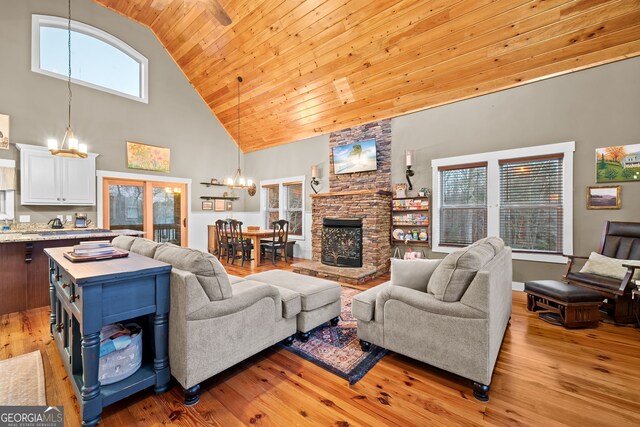 153 Whistle Pig Ter, Blairsville, GA 30512 - living room featuring a chandelier, a stone fireplace, wooden ceiling, light wood-style floors, and high vaulted ceiling