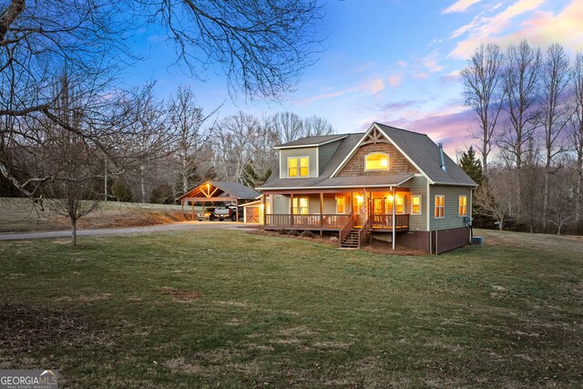 153 Whistle Pig Ter, Blairsville, GA 30512 - back of property at dusk with driveway, a yard, roof with shingles, a detached carport, and a wooden deck