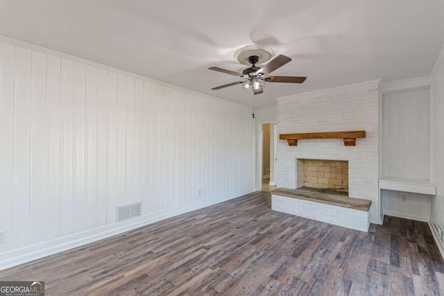 unfurnished living room with wood finished floors, ceiling fan, a fireplace, and crown molding