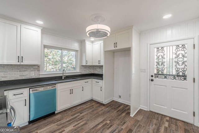 kitchen with a sink, dishwashing machine, dark countertops, and white cabinets