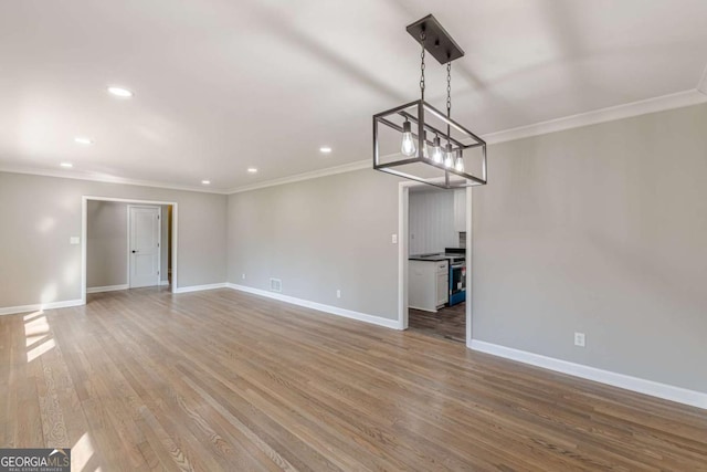 empty room featuring baseboards, wood finished floors, and ornamental molding