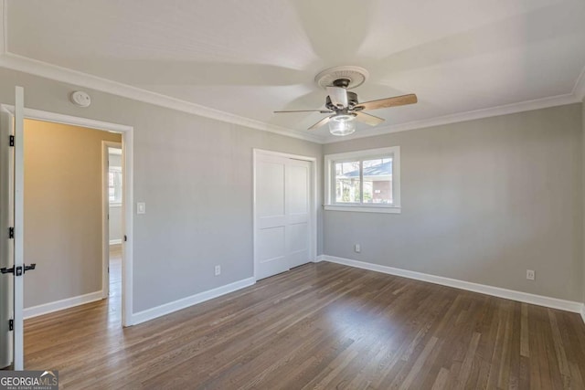 empty room featuring ornamental molding, baseboards, a ceiling fan, and wood finished floors
