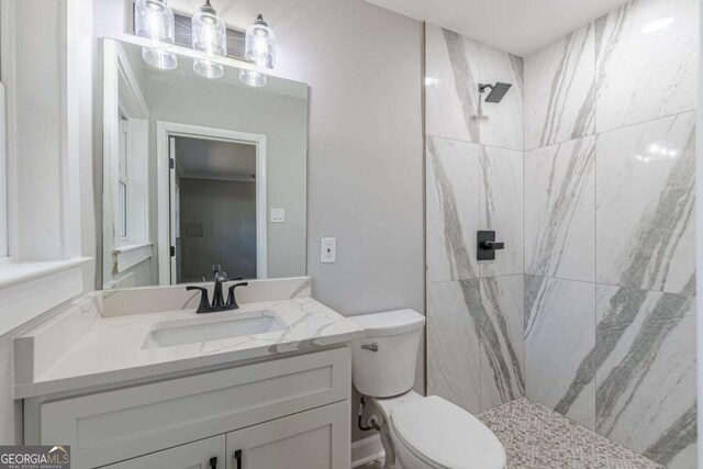 bathroom featuring vanity, toilet, and a marble finish shower