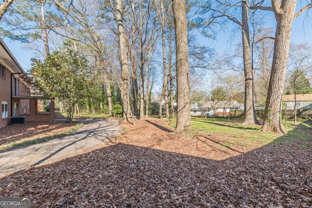 view of yard with cooling unit and driveway