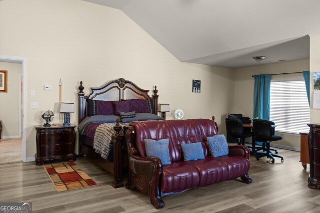 bedroom featuring vaulted ceiling, wood finished floors, and baseboards