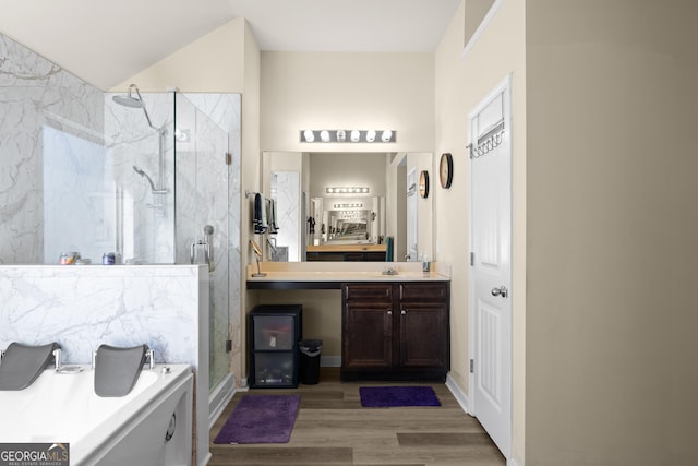 bathroom with a marble finish shower, vanity, and wood finished floors