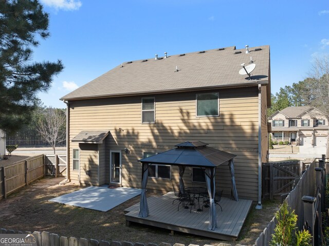 back of house featuring a deck, a gazebo, a gate, and a fenced backyard