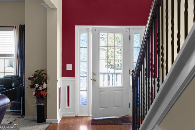 foyer entrance featuring stairs, baseboards, and wood finished floors
