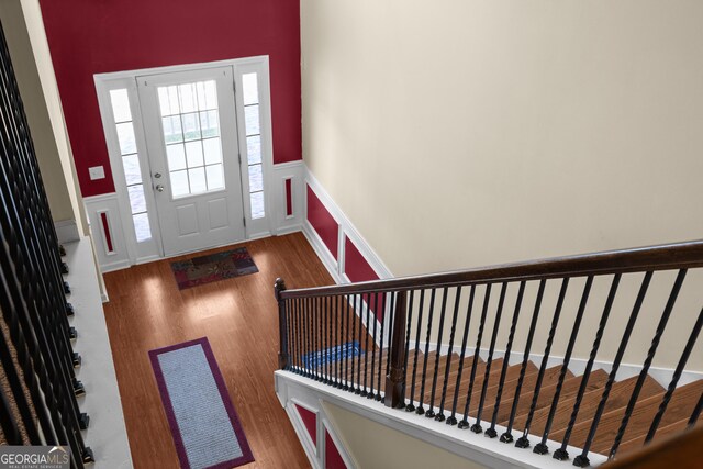 foyer featuring a wainscoted wall, a decorative wall, and wood finished floors