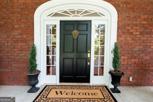 doorway to property featuring brick siding