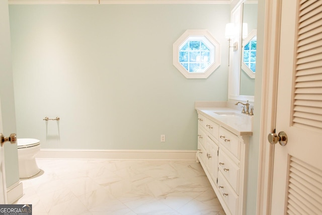 bathroom with baseboards, toilet, marble finish floor, and vanity