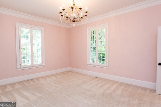 unfurnished room with a chandelier, ornamental molding, and carpet floors
