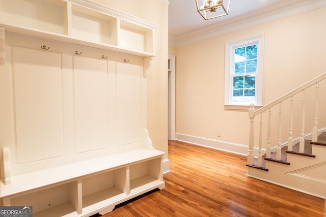 mudroom featuring an inviting chandelier, wood finished floors, baseboards, and ornamental molding
