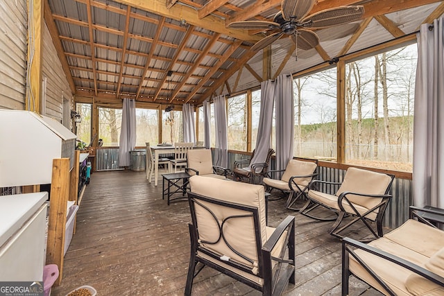 sunroom / solarium featuring a ceiling fan, vaulted ceiling, hardwood / wood-style flooring, and a deck