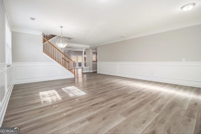 4319 Alysheba Dr, Fairburn, GA 30213 - unfurnished living room with stairs, ornamental molding, wood finished floors, a wainscoted wall, and a decorative wall