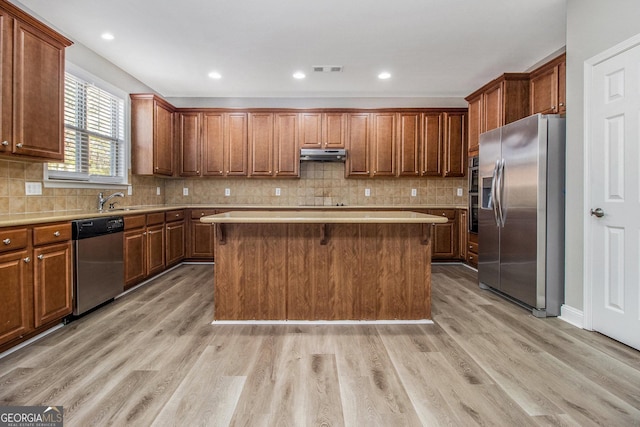 4319 Alysheba Dr, Fairburn, GA 30213 - kitchen featuring stainless steel appliances, under cabinet range hood, a kitchen island, light countertops, and light wood-style floors
