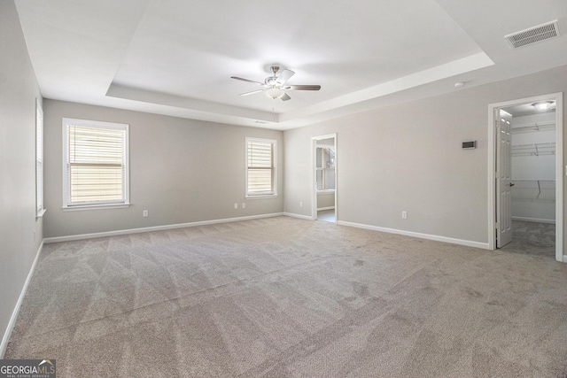 4319 Alysheba Dr, Fairburn, GA 30213 - unfurnished bedroom featuring a raised ceiling, a walk in closet, carpet flooring, and a ceiling fan