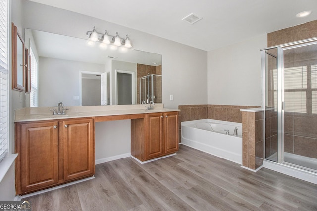 4319 Alysheba Dr, Fairburn, GA 30213 - full bathroom with double vanity, a garden tub, a stall shower, and wood finished floors
