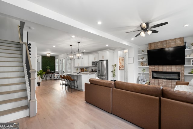 1290 Westboro Dr SW, Atlanta, GA 30310 - living room with light wood-type flooring, a ceiling fan, recessed lighting, a fireplace, and stairs