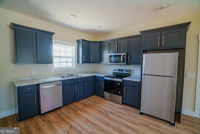 42 Walton Way, Hazlehurst, GA 31539 - kitchen with stainless steel appliances, blue cabinets, light countertops, and light wood-style floors