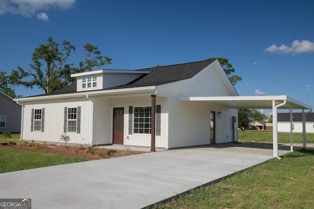 42 Walton Way, Hazlehurst, GA 31539 - view of front facade featuring concrete driveway, an attached carport, a shingled roof, and a front yard