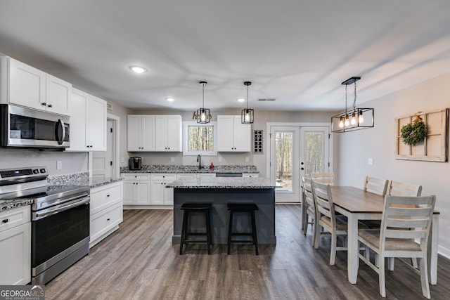 132 Pinnacle Way, Carrollton, GA 30117 - kitchen with light stone countertops, a kitchen bar, stainless steel appliances, white cabinetry, and a sink