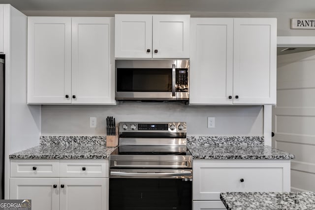 132 Pinnacle Way, Carrollton, GA 30117 - kitchen with white cabinets, light stone counters, and appliances with stainless steel finishes