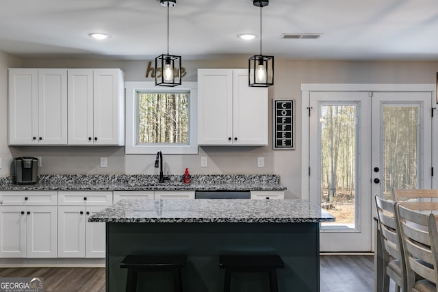 132 Pinnacle Way, Carrollton, GA 30117 - kitchen with dark wood finished floors, white cabinets, light stone counters, and visible vents