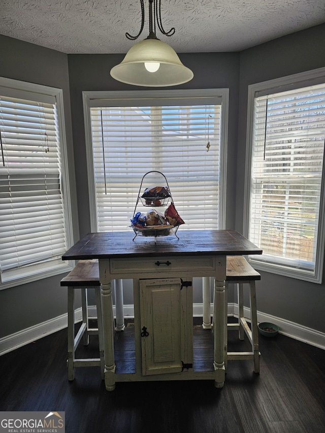 dining area featuring baseboards, dark wood finished floors, and plenty of natural light