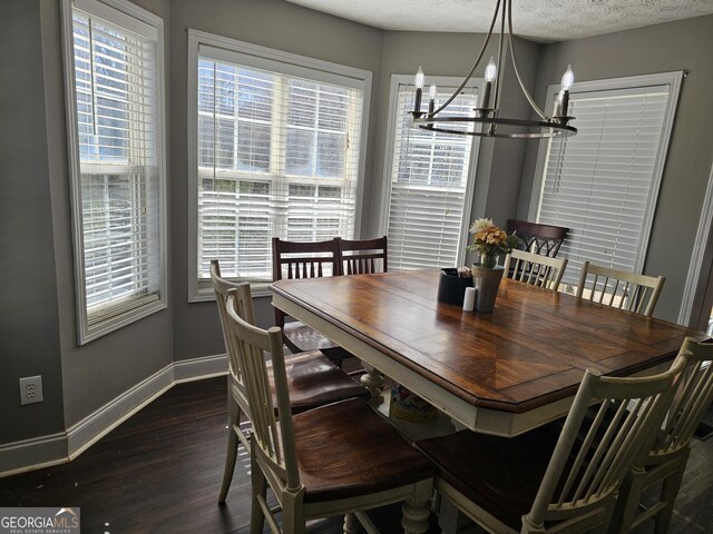 dining area featuring baseboards, a notable chandelier, dark wood-style floors, and plenty of natural light