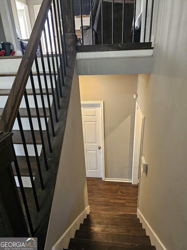 stairway with wood finished floors and baseboards