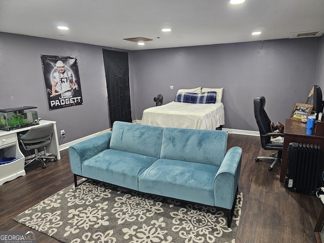 bedroom with visible vents, baseboards, and wood finished floors