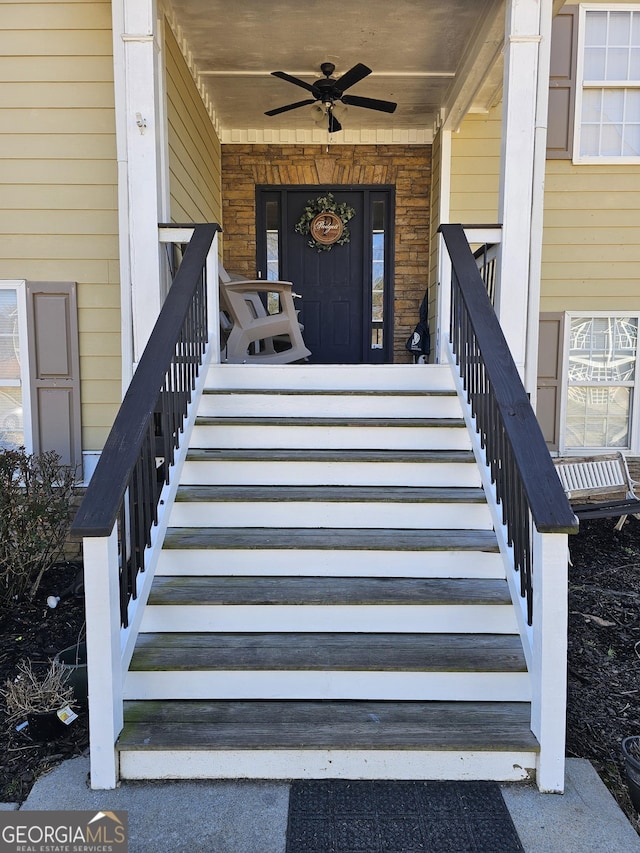 doorway to property featuring covered porch and a ceiling fan