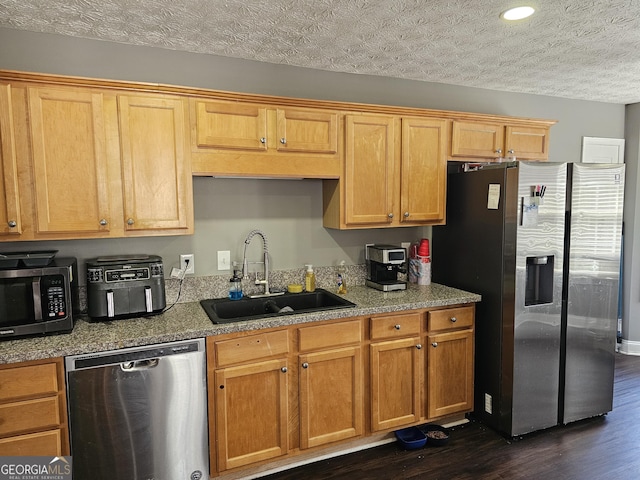 kitchen featuring dark wood-type flooring, a textured ceiling, recessed lighting, a sink, and stainless steel appliances