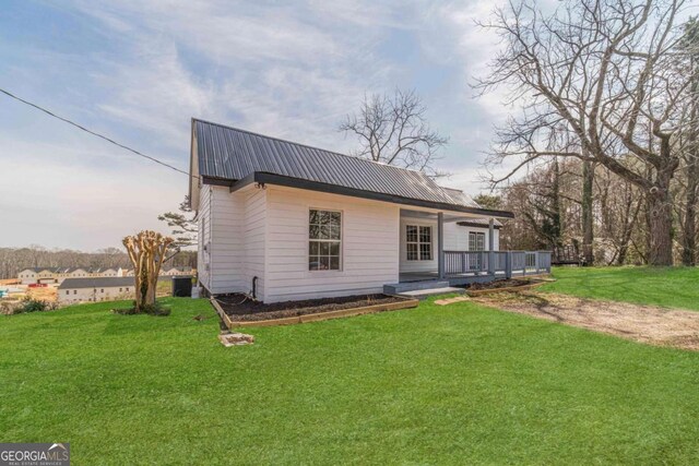 view of front of property with a front lawn, a porch, and metal roof