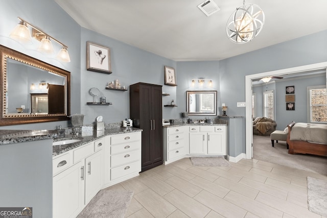ensuite bathroom with ceiling fan, visible vents, two vanities, a sink, and ensuite bathroom
