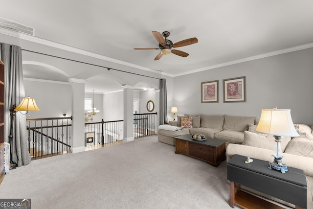 living area featuring a ceiling fan, visible vents, crown molding, arched walkways, and ornate columns