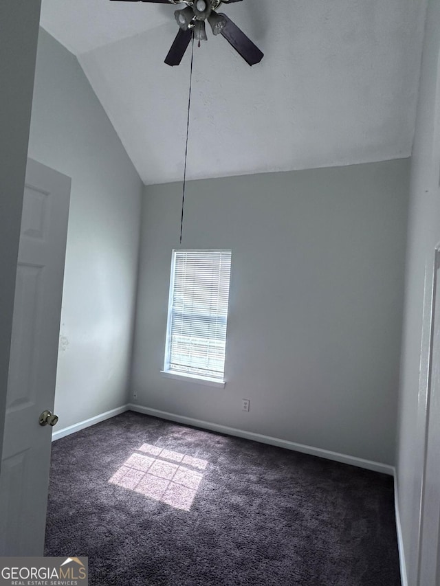 carpeted spare room featuring baseboards, a ceiling fan, and vaulted ceiling