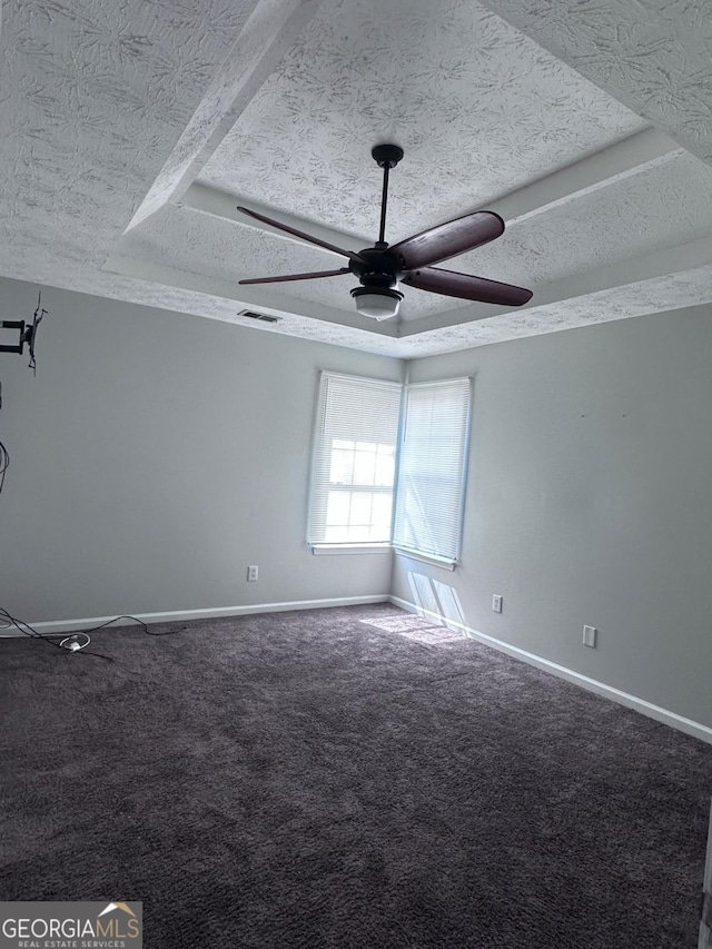 spare room featuring visible vents, baseboards, carpet, a textured ceiling, and a ceiling fan