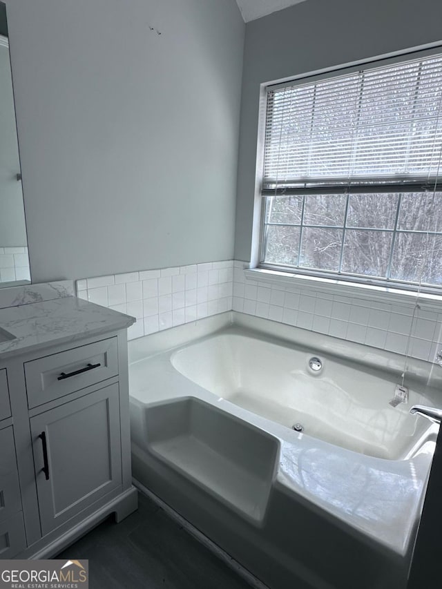 bathroom with vanity and a garden tub