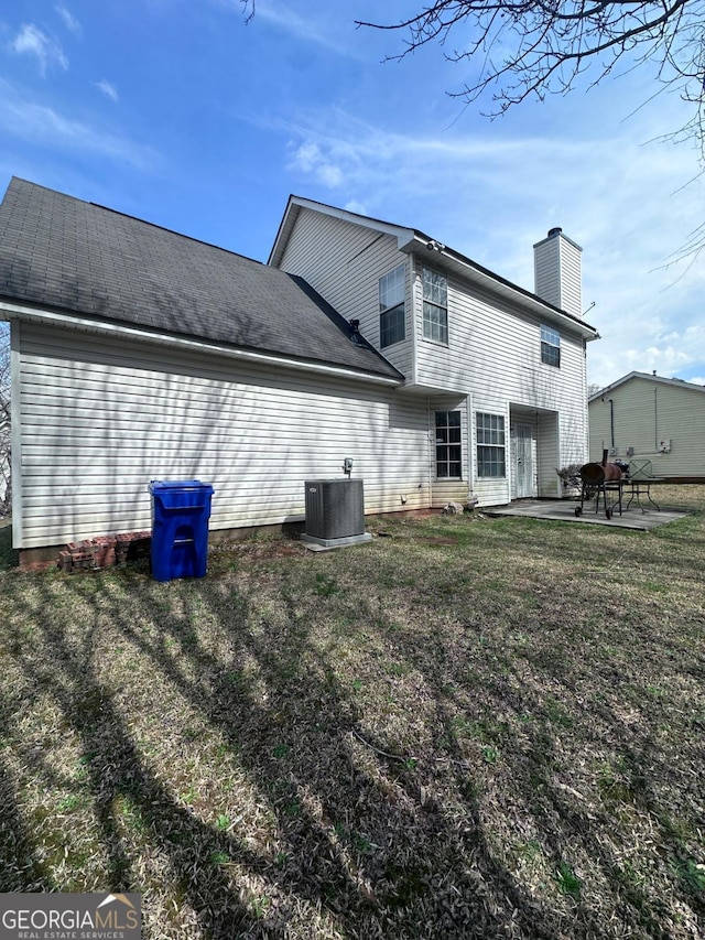 back of house with a patio area, central AC unit, a chimney, and a yard