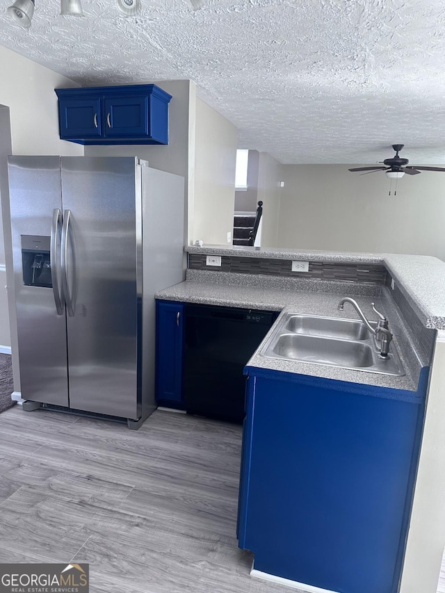 kitchen with a sink, dishwasher, blue cabinets, and stainless steel fridge with ice dispenser