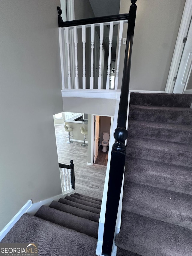 stairs with baseboards and wood finished floors