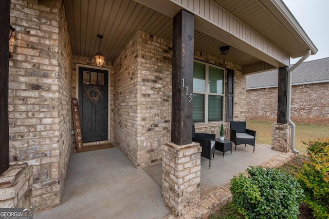 property entrance with a porch and brick siding