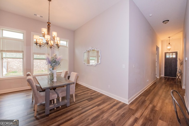 dining area featuring dark wood finished floors, an inviting chandelier, and visible vents