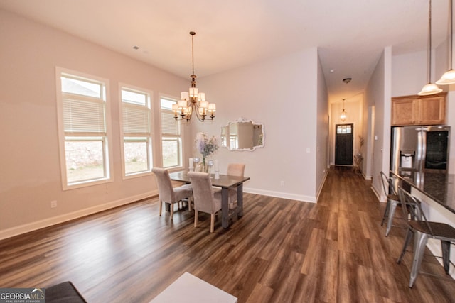 dining room featuring a chandelier, baseboards, and dark wood finished floors
